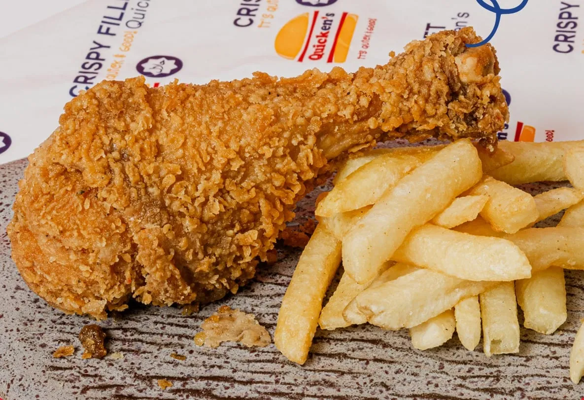 A fried chicken drumstick with chips on Quicken’s branded paper