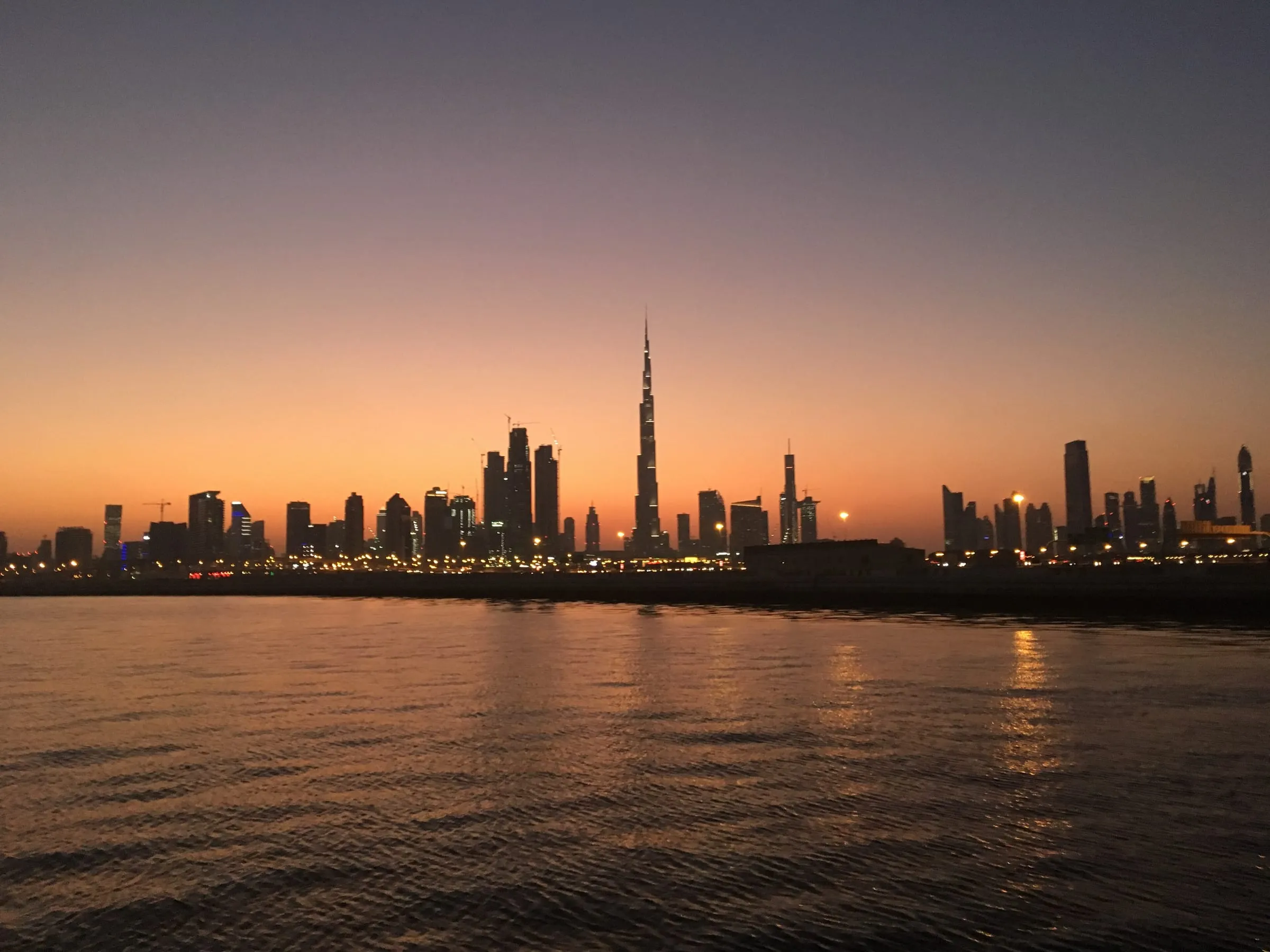 The Dubai skyline and Burj Khalifa at dusk, seen across the water